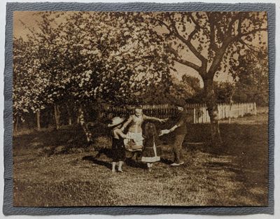 une vieille photo représentant une femme et un enfant dans la cour