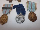 three medals are sitting on a table with a ribbon around them