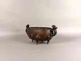 an old bronze bowl with a statue on the side