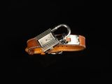 une ceinture en cuir orange avec une boucle argentée sur fond noir