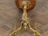a gold vase sitting on top of a wooden floor