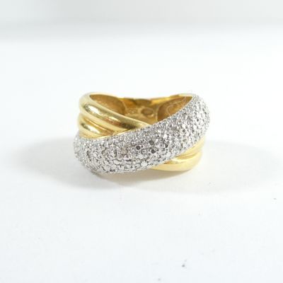 gros plan d'une bague en or et diamants sur une surface blanche