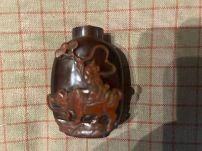 un vase marron orné d'un dragon, posé sur une table