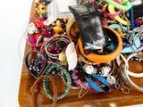 un plateau en bois rempli d'un assortiment de bijoux et de bracelets