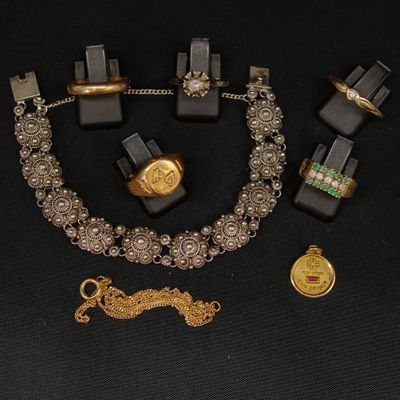 un collier, un bracelet, une bague et d'autres bijoux posés sur une table