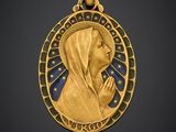 une image représentant un pendentif en or sur lequel figure une femme en train de prier