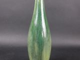 a green vase that is sitting on a black surface
