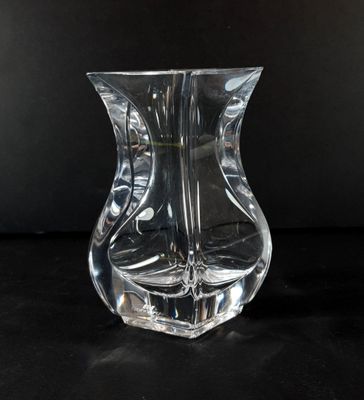 a clear glass vase sitting on a black surface