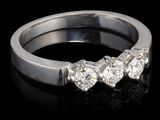 gros plan d'une bague en diamant sur une surface noire