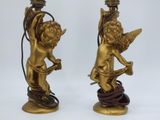 pair of antique brass figurines of cherensils on a stand