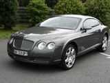 La Bentley est garée sur le parking, près des arbres.