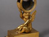 gold plated figurine of a cupid holding a mirror