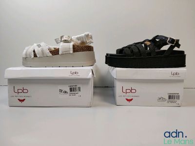 deux paires de sandales noires et blanches posées sur une boîte