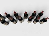 several bottles of wine are lined up in a row on a white surface