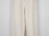 un pantalon blanc suspendu à un cintre contre un mur