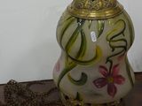 a vase with a chain on a table next to a wall