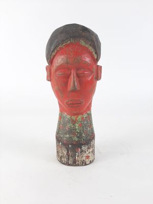 a red statue of a man with a hat on his head