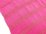 a close up of a pink and gold striped pillow on a white table