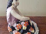 a figurine of a woman sitting on a table