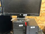 un ordinateur de bureau posé sur un bureau, à côté d'un écran et d'un clavier