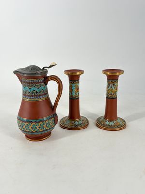 three small vases and a small pitcher sitting on a table