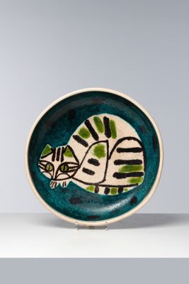 une petite assiette ornée d'un chat, posée sur une table