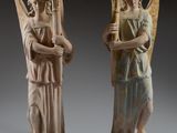 deux statues d'anges tenant des harpes et se tenant l'une à côté de l'autre