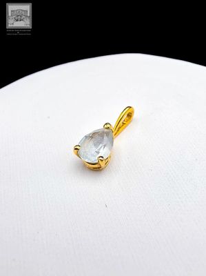 un gros plan d'un pendentif plaqué or orné d'un quartz transparent