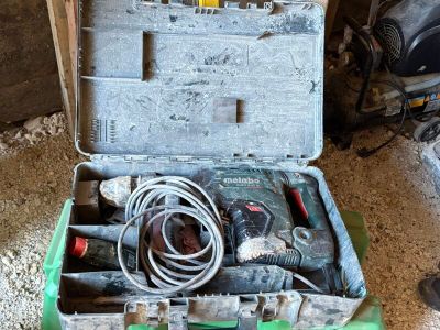 une boîte à outils contenant des outils, posée sur le sol