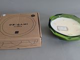 a candle in a green glass bowl next to a box