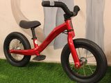 a small red bike that is sitting on the grass