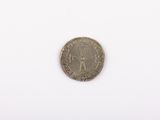 an old silver coin on a white surface with a white background