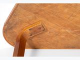 a small wooden table with a bent leg on it