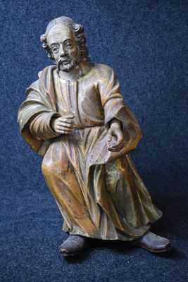 statue of a man sitting on a chair with a book in his lap