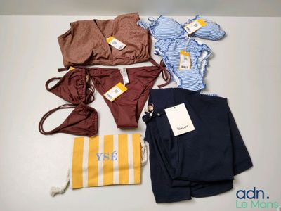beaucoup de vêtements et un sac posés sur une table
