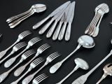 a lot of spoons and forks on the table