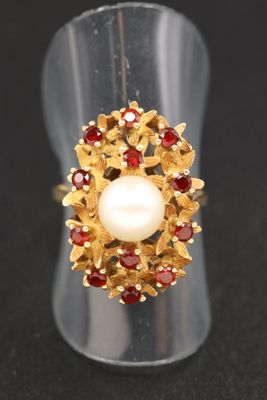 un gros plan d'une bague ornée d'une perle et de grenats
