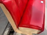 a red bench that is sitting on the side of the road