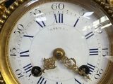 a gold clock with a bird on top of it