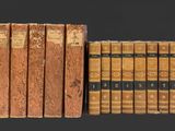 Plusieurs vieux livres sont alignés sur une surface noire