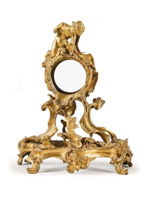 un miroir doré richement décoré, surmonté d'un oiseau