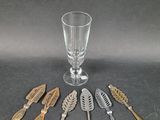 five spoons and a glass on the table