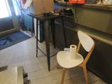 a white chair sitting in front of a counter with a roll of toilet paper on it
