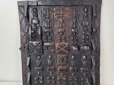 une plaque en bois comportant des sculptures sur un fond blanc