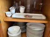 a cabinet with plates and cups in it