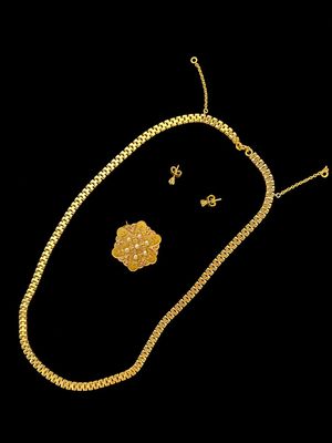 un ensemble composé d'un collier et de boucles d'oreilles en or sur fond noir