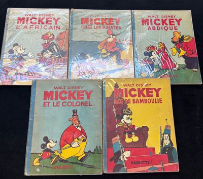 Quatre livres de Mickey Mouse sont alignés sur une surface noire
