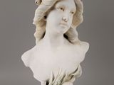 a white busturine of a woman with long hair and a flower in her hair