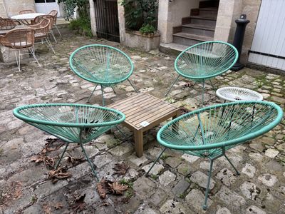quatre chaises et une table dans la cour d'une maison