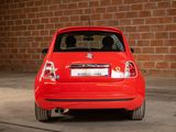 a small red car parked in front of a brick wall